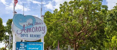 A sign for Amy Slate's Anoray Dive Resort with amenities including SCUBA Diving, Snorkeling, and Sunset Cruises.