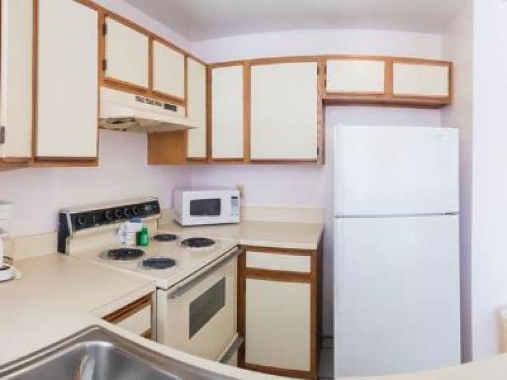 Una cocina compacta con estufa, microondas y refrigerador.