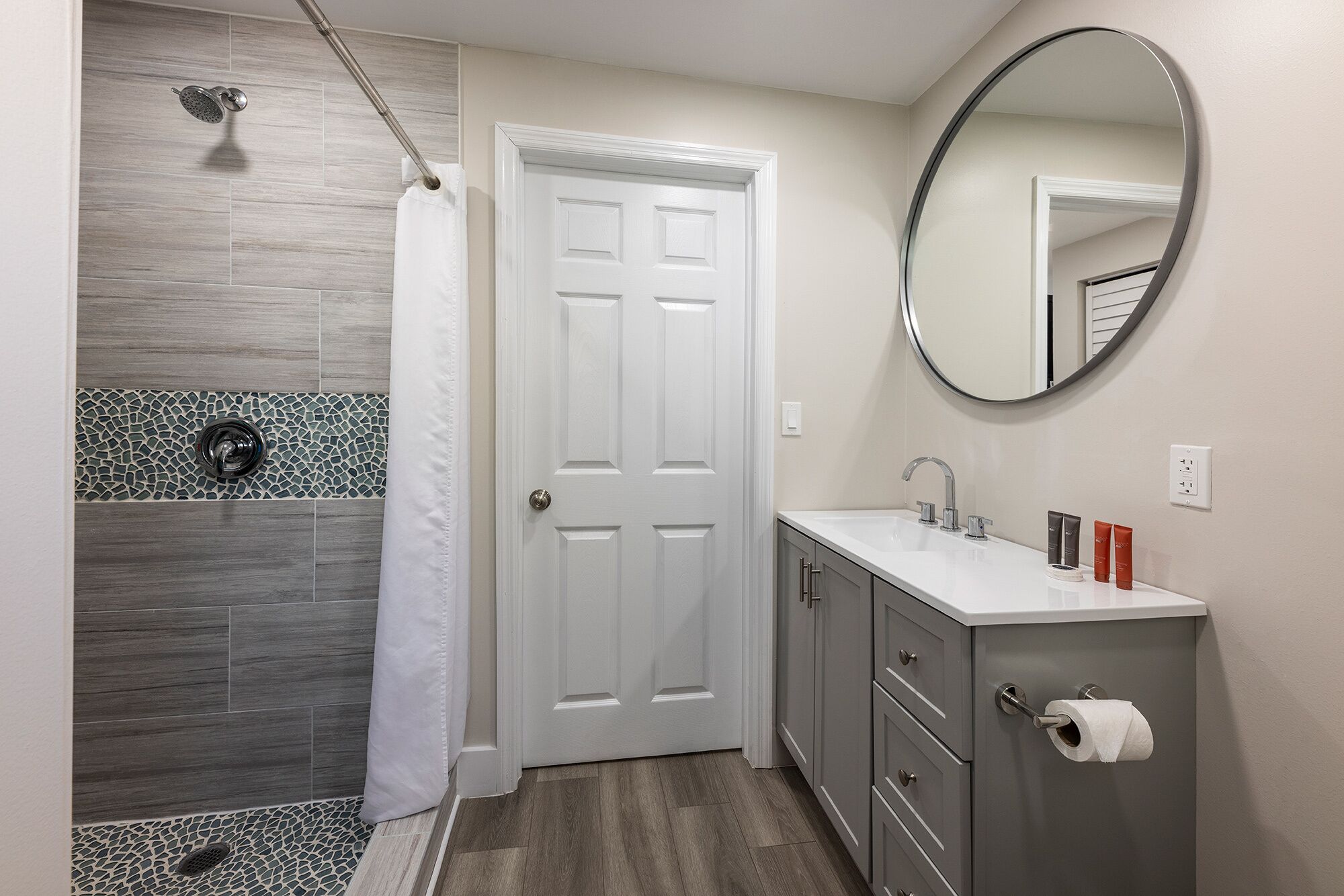 Une salle de bain équipée d’une douche, de toilettes, d’un lavabo et d’un miroir.