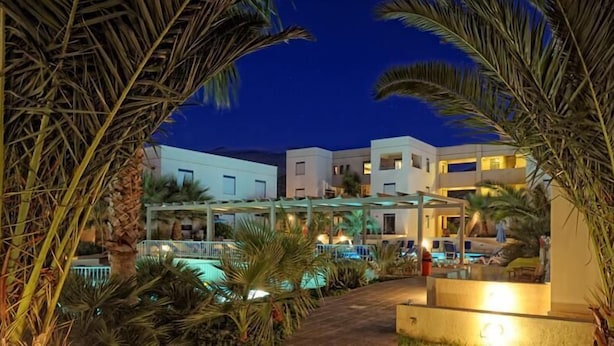 A resort with a swimming pool, palm trees, and modern buildings at twilight. - Meropi Hotel & Apartments (Hersonissos)