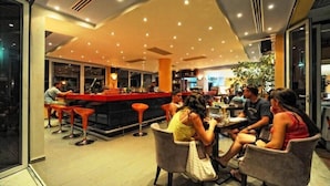 A modern restaurant with a bar area, seating for guests, and a visible kitchen in the background. - Meropi Hotel & Apartments (Hersonissos)