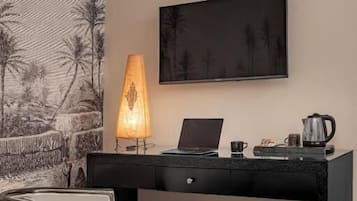 Una habitación de hotel con escritorio, silla y un cuadro grande en la pared.
