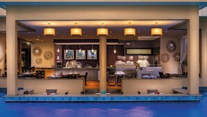 A poolside bar area with seating and a kitchen in the background. - Grand Plaza (Marrakech)