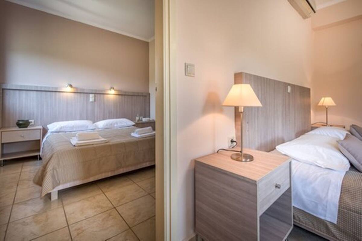 Hotellihuone, jossa on sänky, yöpöydät ja lamput.