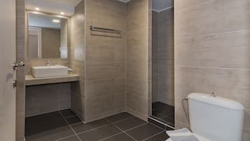 A modern bathroom with a sink, mirror, and toilet.