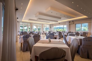 Una sala conferenze con tavoli e sedie, ampie finestre e un moderno design del soffitto.