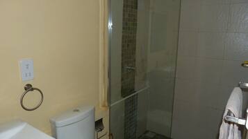 A bathroom with a toilet, a glass shower enclosure, and a towel rack.