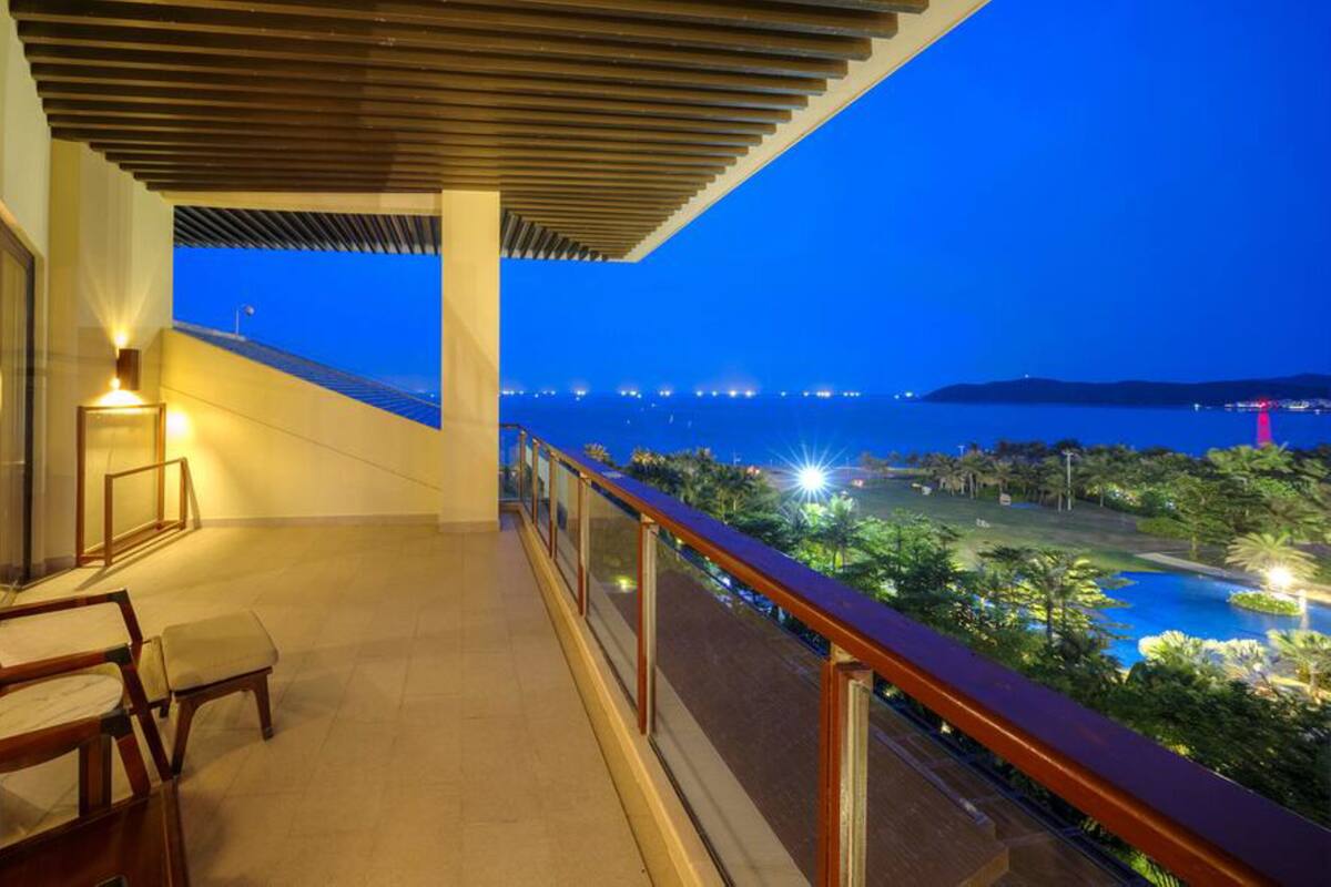 Un balcon avec vue sur la mer, une chaise et une table.