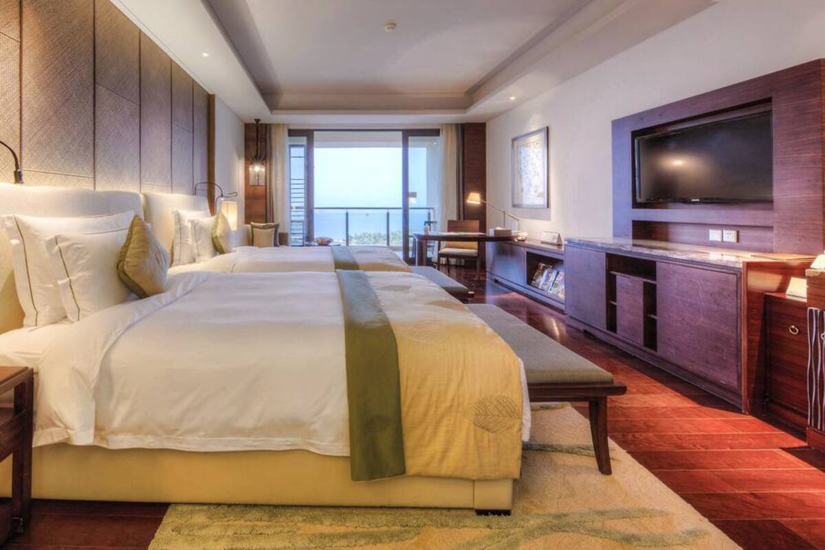 Une chambre d’hôtel avec un grand lit, une télévision, un bureau et une vue sur l’extérieur.