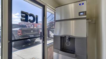 Un intérieur commercial comprenant un distributeur d’eau, une porte avec une pancarte et une vue sur un parking.