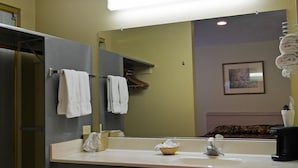 A bathroom with a mirror, a sink, a towel rack, a basket, and a coffee maker. - SureStay by Best Western Yerington (Yerington)