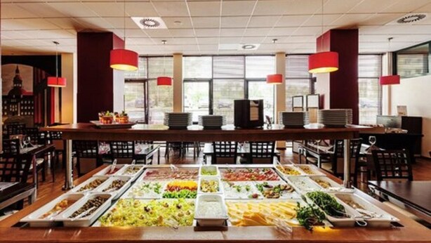 A buffet setup with various food items and red pendant lights. - Economy Silesian Hotel (Katowice)