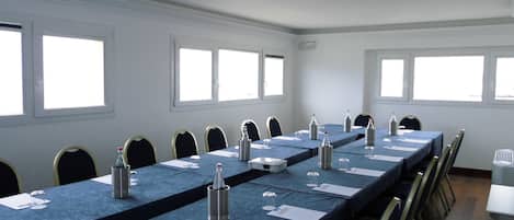 A conference room with a long table, chairs, and a projector.