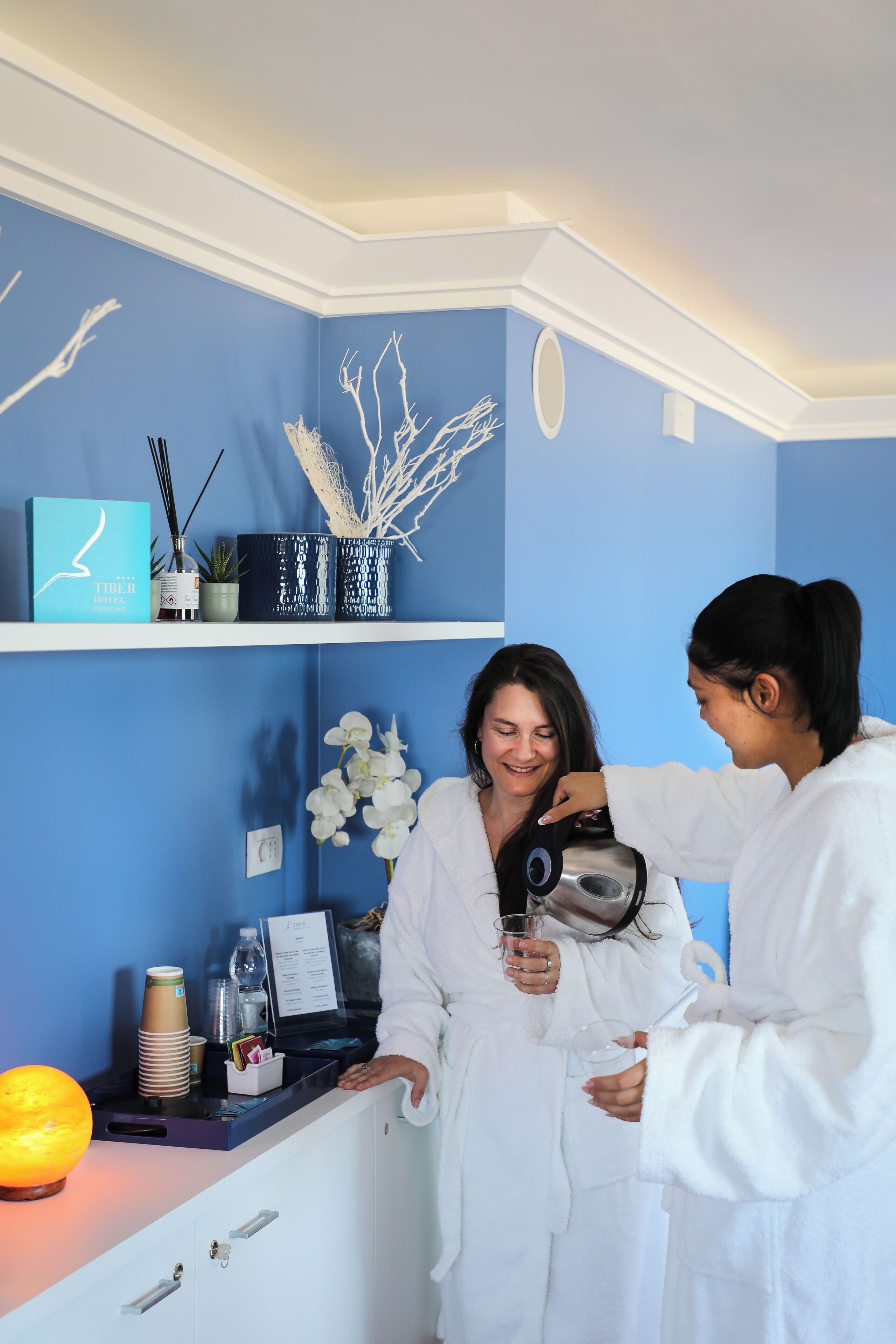 A room with a blue wall, a white reception desk, and a decorative plant.