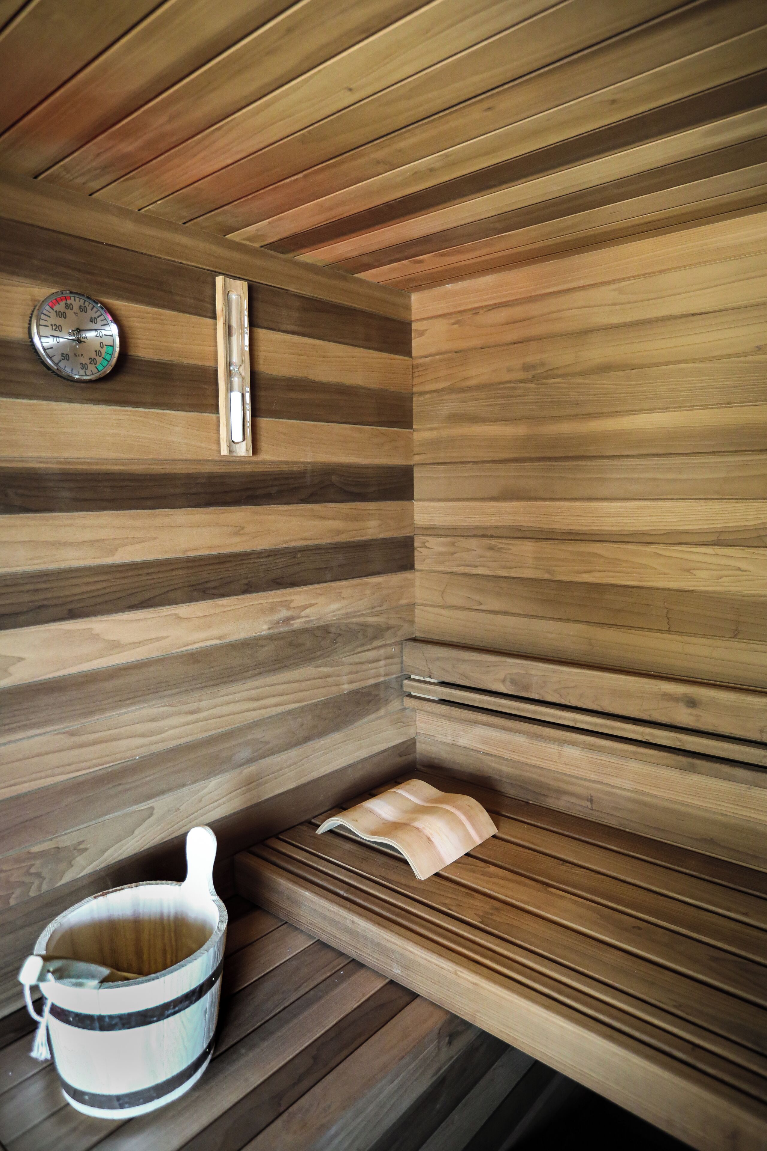 Un sauna avec des murs en bois et un banc.
