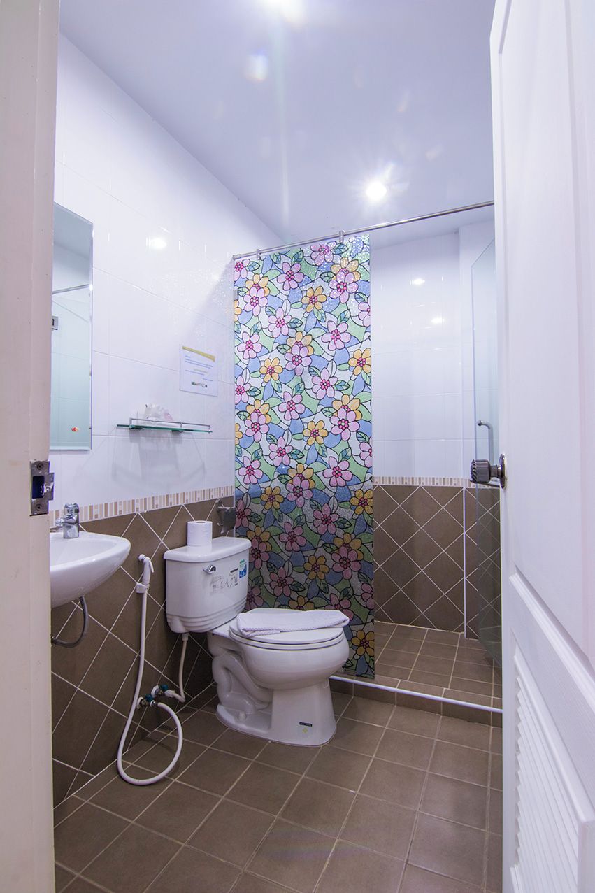 Ein Badezimmer mit Toilette, Waschbecken und Duschbereich.