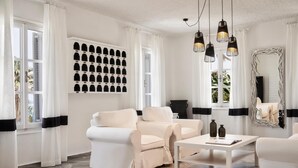 En moderne stue med et hvidt sofasæt, et hvidt sofabord og et dekorativt spejl.