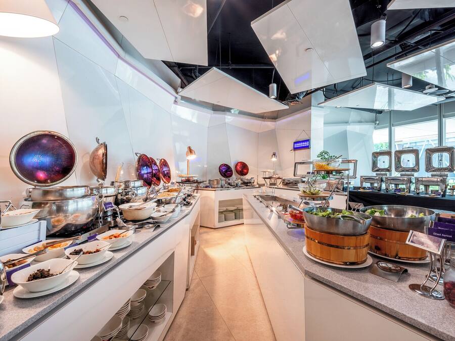 A buffet setup with various food stations and serving utensils.