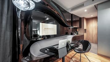 Una cocina moderna con una encimera curva, una computadora portátil y una silla.