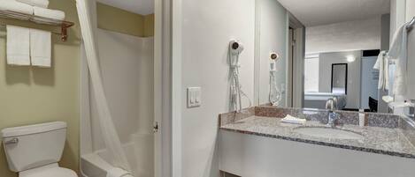 A bathroom with a shower, toilet, and sink.
