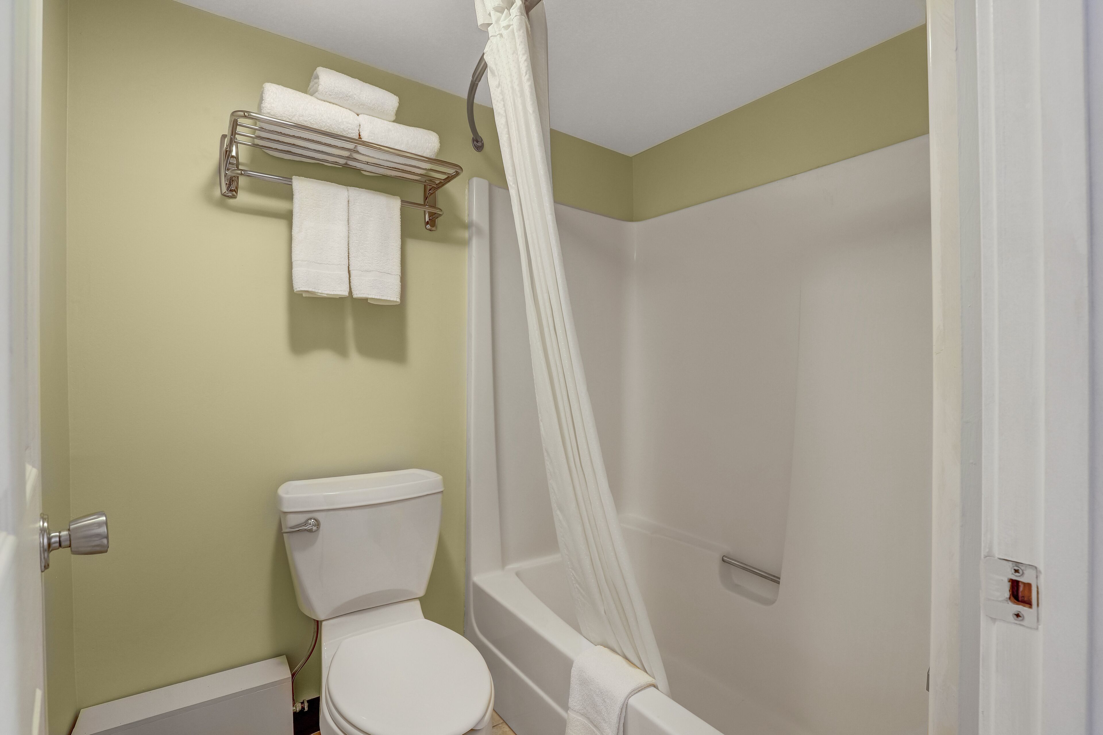 Une salle de bain équipée de toilettes, d’une baignoire et d’un rideau de douche.