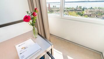 Habitación de hotel con vista a un paisaje urbano y una masa de agua.