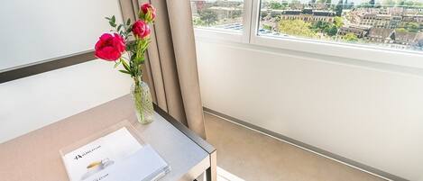 Habitación de hotel con vista a un paisaje urbano y una masa de agua.