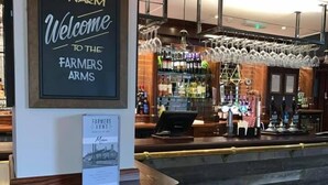 A bar area with a sign reading "A WARM Welcome to the Farmers Arms." - The Farmers Arms (Richmond)