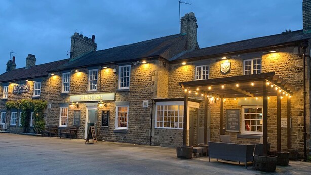 A stone building with a sign reading "Farmers Arms" and a pub sign indicating re-opening on Friday and October 26th. - The Farmers Arms (Richmond)
