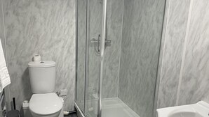 A modern bathroom with a glass-enclosed shower, a toilet, and a sink. - The Farmers Arms (Richmond)