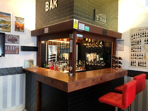 A bar area with a brick counter, a red chair, and various liquor bottles. - The Franklyn Hotel (Blackpool)