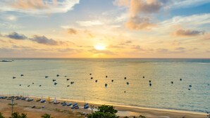 Una playa con barcos y una puesta de sol.