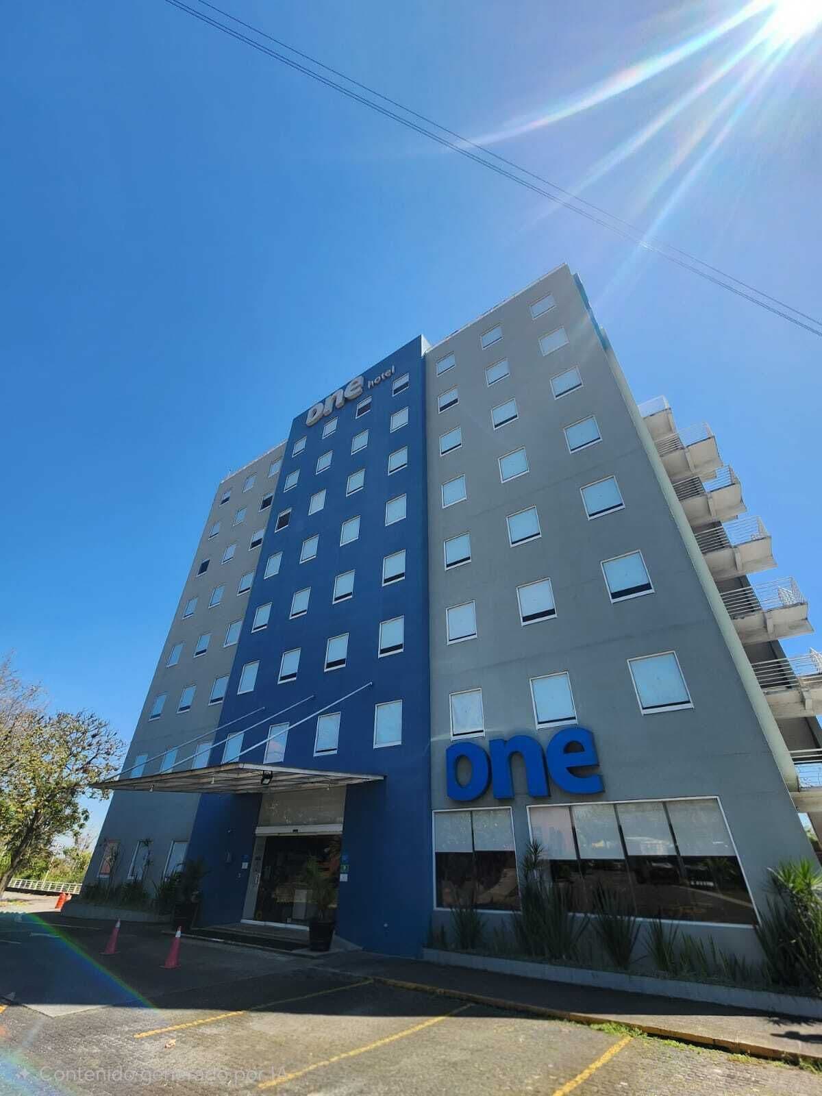 A multi-story hotel building with the name 'one hotel' prominently displayed on the facade.