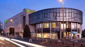 A modern hotel with a curved glass facade, a prominent 'ibis Suites' sign, and a 'Space on Ligne' restaurant visible through the windows. - ibis Styles Bordeaux Saint Médard (Saint-Medard-en-Jalles)