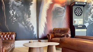 A room with leather sofas, a dartboard, and a chessboard. - ibis Styles Bordeaux Saint Médard (Saint-Medard-en-Jalles)