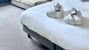 Une chambre d’hôtel avec un grand lit, un canapé, une table de chevet avec une lampe et une vue sur l’extérieur.