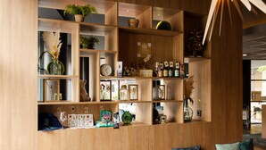 Une étagère en bois sur laquelle sont disposés divers objets, notamment des plantes, une horloge et des objets décoratifs.