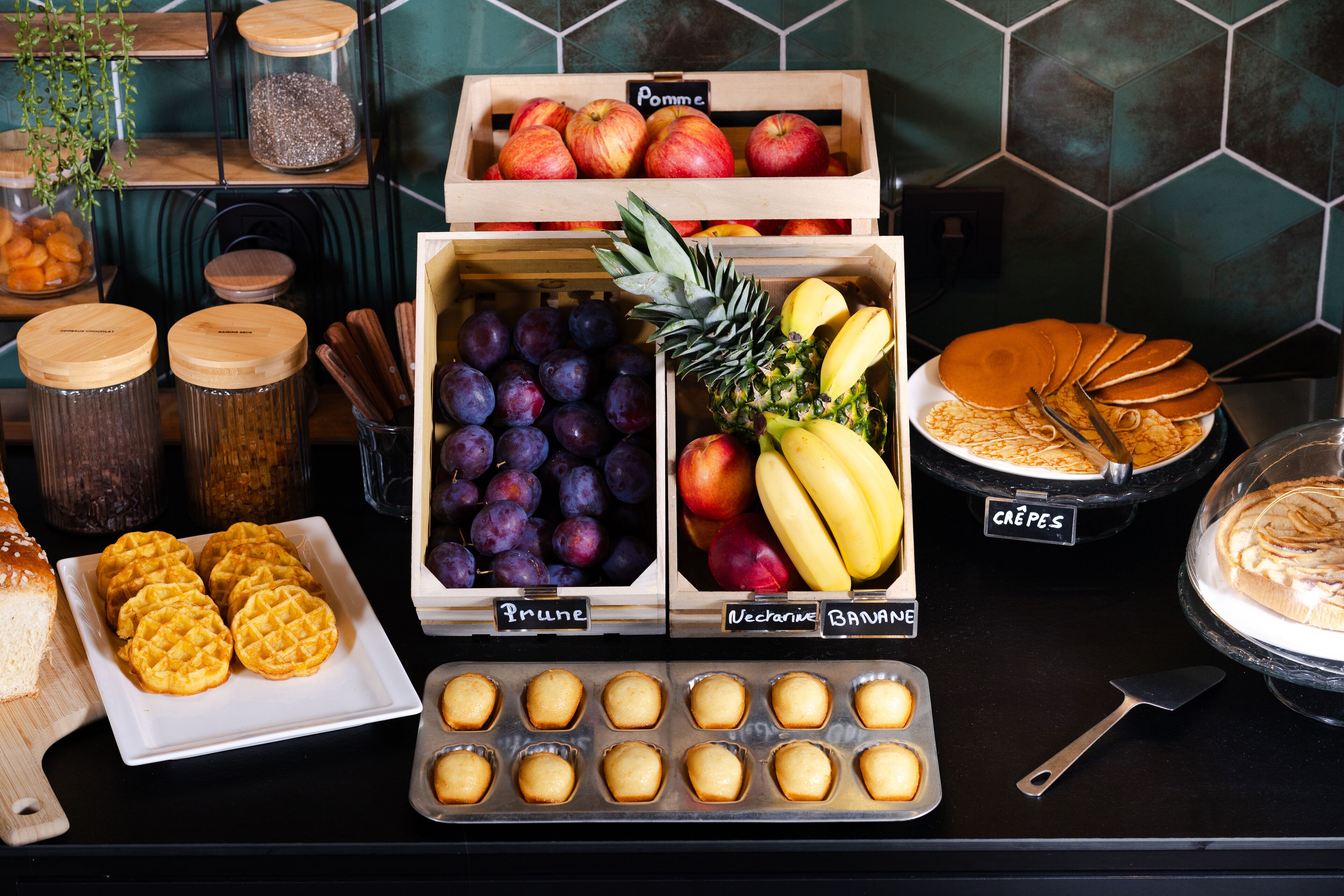 A display of various fruits and pastries in a bakery setting.