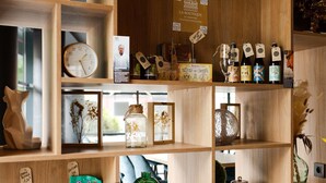 Une étagère en bois sur laquelle sont disposés divers objets, notamment une horloge, des photos encadrées et des bouteilles.