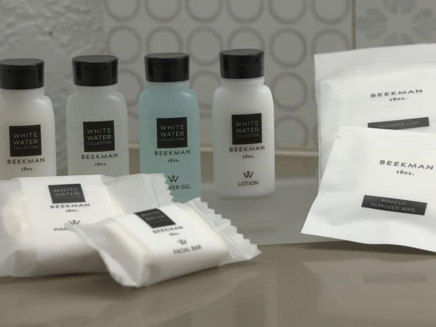 A collection of skincare products from the Beekman brand, including lotions, a facial bar, and a remover wipe.