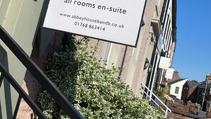 A sign for Abbey House B&B advertising all rooms as en-suite with a website and phone number. - Abbey House Bed and Breakfast (Penrith)