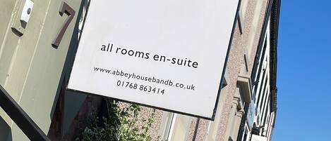 Letrero de Abbey House B&B que anuncia que todas las habitaciones tienen baño propio.