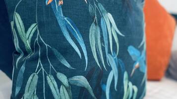 A pillow with a bird and leaves design.