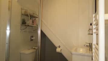 Ein Badezimmer mit Toilette, Waschbecken und einer Duschkabine aus Glas.