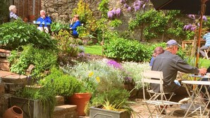A garden patio with stone steps, potted plants, and outdoor seating. - Bridge House (Tiverton)