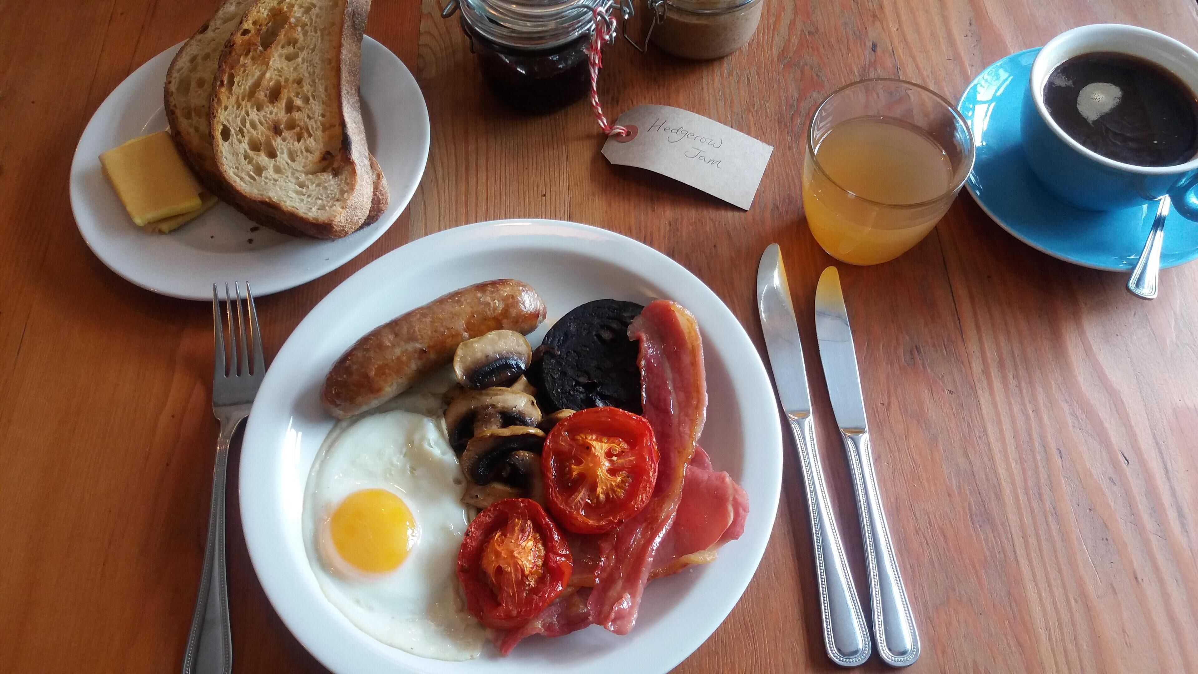 A breakfast plate with eggs, bacon, mushrooms, and tomatoes.