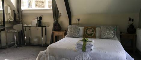 Un dormitorio con cama, escritorio, silla y ventana.