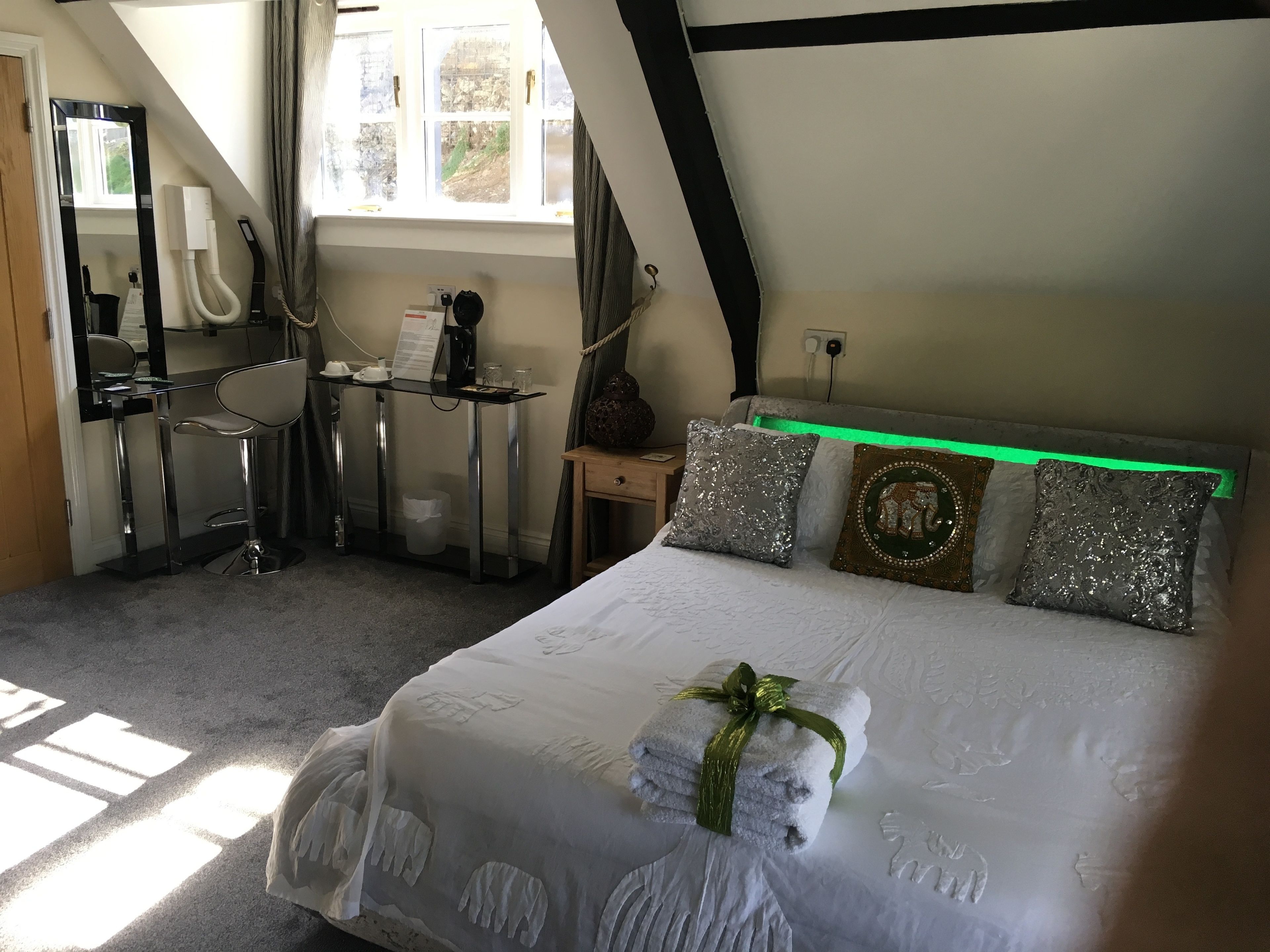 A bedroom with a bed, a desk, and a chair.
