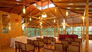 Une vaste salle en bois, dotée de hauts plafonds et de nombreux luminaires suspendus.
