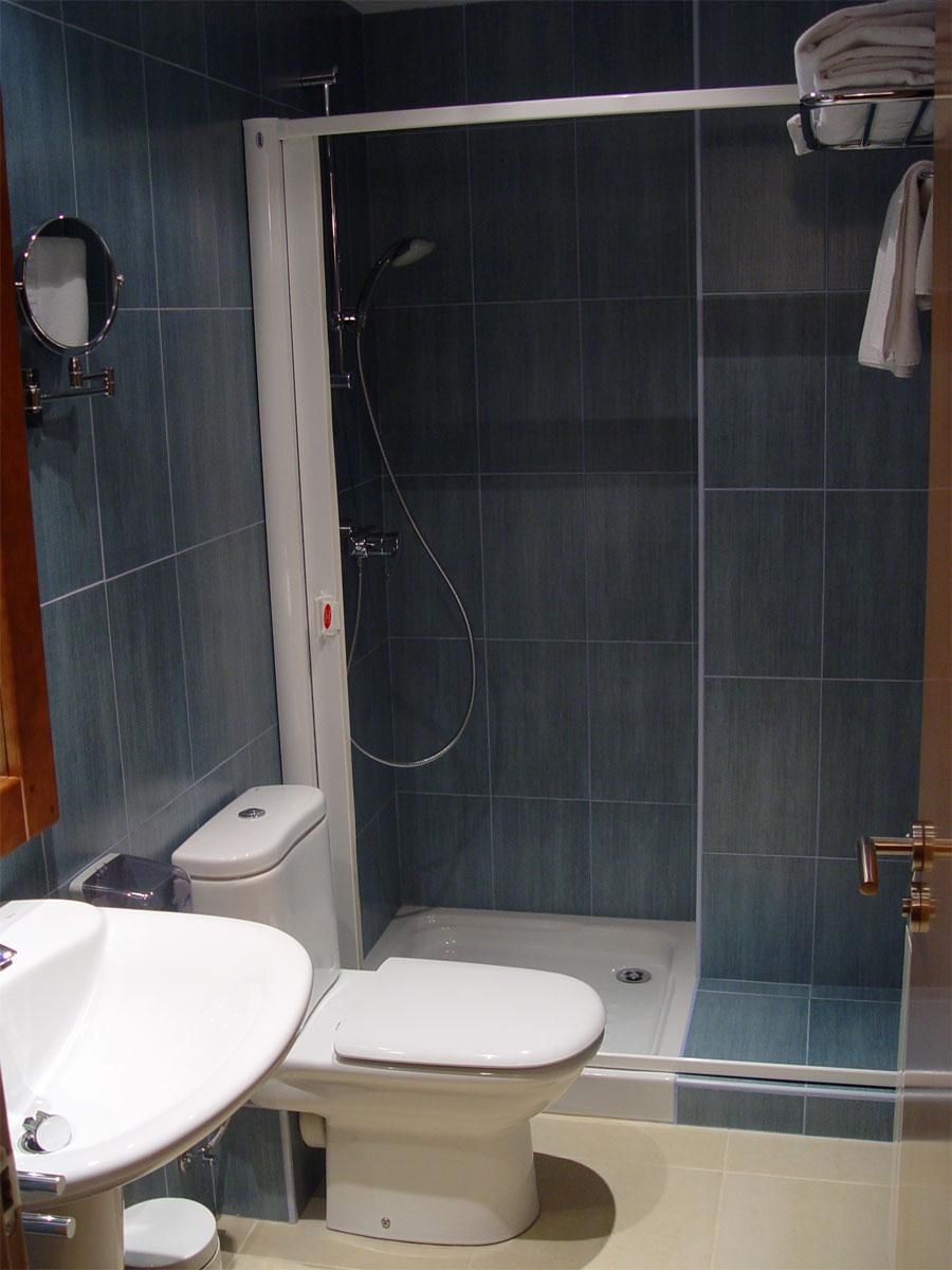 Une salle de bain comprenant des toilettes, un lavabo et un espace douche.